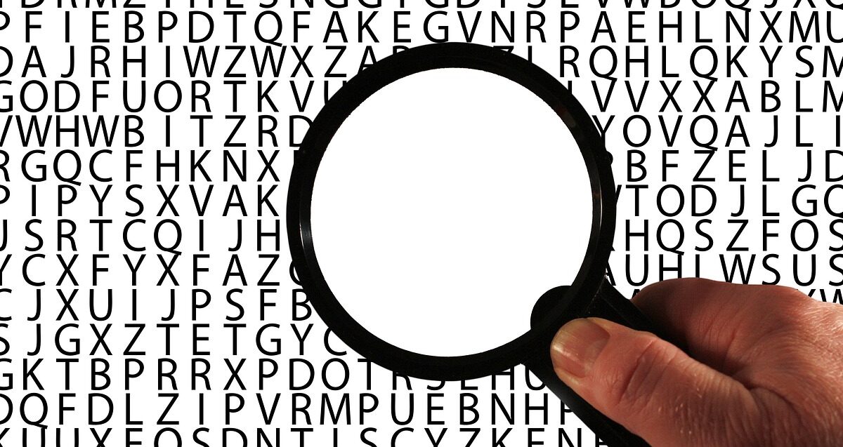 Magnifier glass over a bunch of letters