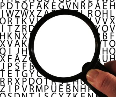 Magnifier glass over a bunch of letters