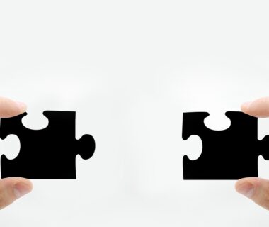 Hands holding two puzzle pieces that fit together