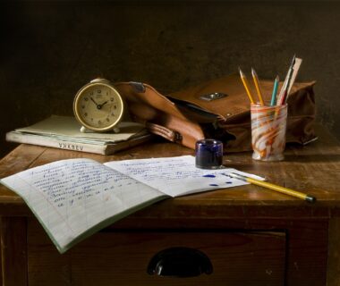 Workbook with pencils and a clock